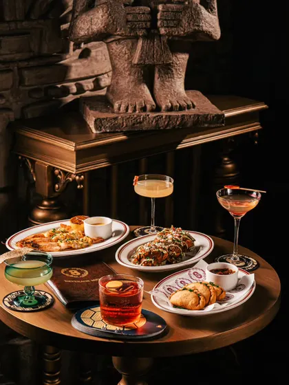 A table setting at Ocho Bandra with a moody, mysterious ambiance. The dark lighting and stone decor elements create a unique and sophisticated atmosphere.