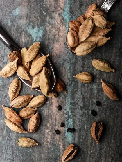 Felt like putting some chai on the feed. A rustic, moody flat-lay of cardamom pods and peppercorns on a textured background, evoking the aromatic spices of a perfect cup of chai.