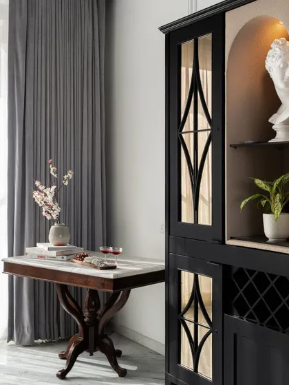 Every corner should tell a story. Here, a vintage-style bar cabinet is paired with a marble-topped table, creating a dedicated space for entertaining that feels both classic and personal.