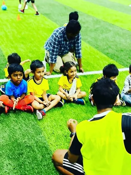 A group of our youngest players sits attentively as two coaches explain the next activity. We maintain a high coach-to-student ratio to ensure every child gets the attention they need.