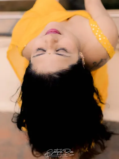 An artistic overhead shot of the yellow saree, capturing the flow of the fabric and hair.