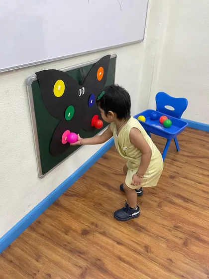 Leaning in for a closer look, this child is fully engaged with the butterfly activity. We create a learning environment that encourages curiosity and active participation.