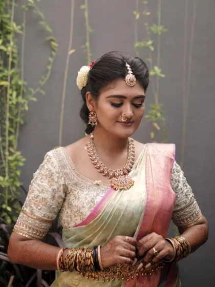 A candid, downward glance that highlights the soft eyeshadow and the intricate details of her jewellery.
