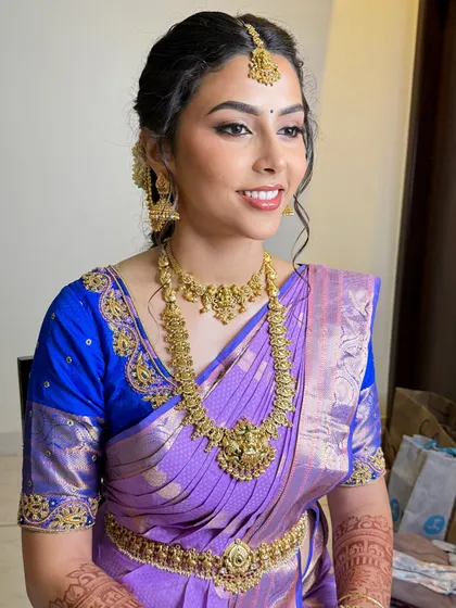 The final look, showcasing the beautiful harmony between the makeup, hairstyle, and the royal blue and purple saree.