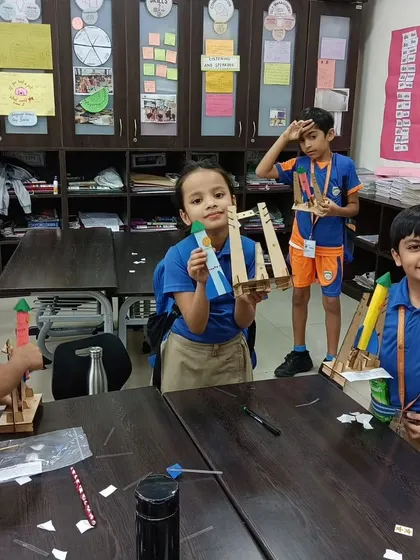 In a classroom setting, students proudly display the rockets they built during one of our school workshops, demonstrating hands-on physics principles.
