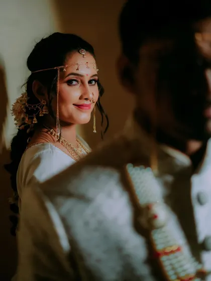 An intimate and artistic shot of the bride looking at her groom, her face partially illuminated in a play of light and shadow.