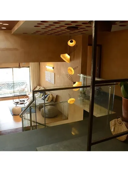 Looking down from the staircase into the double-height living space. The design uses verticality to create a sense of spaciousness and drama.