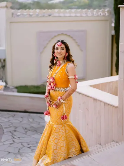 A full view of the custom marigold mermaid skirt and hand-embroidered blouse. This outfit combines a traditional Banarasi fabric with a modern fish-cut silhouette, perfect for a bride who wants a unique Haldi look.