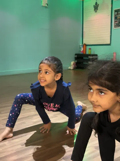 Young dancers in a deep lunge, showing their focus and the strength they are building in their legs.