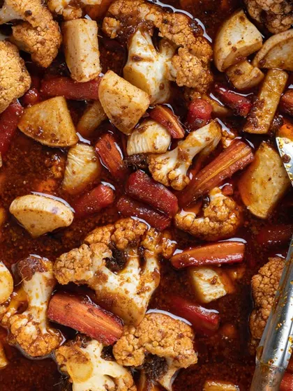 This is a macro, top-down shot of mixed vegetable pickle. The extreme close-up reveals all the intricate details and textures of the vegetables and spices, showing the complexity of the product.