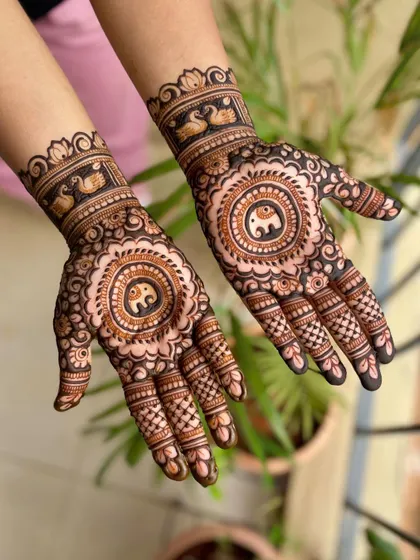 A full view of the engagement mehendi with elephant mandalas and swan wristbands.