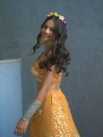 A side view of the boho Haldi look, showing the beautiful floral crown and loose, romantic curls.