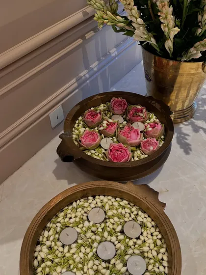 A closer look at the brass urlis. The combination of water, flowers, and floating candles is a traditional way to welcome guests and bring positive energy into a home.
