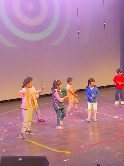 A group of boys and girls practicing a dance number, their energy and enthusiasm lighting up the stage.