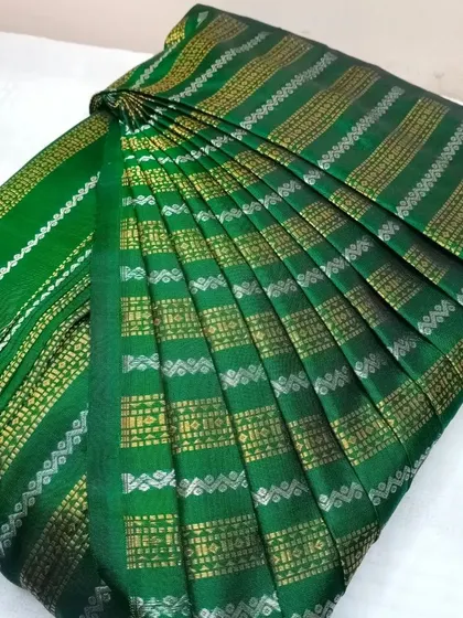 This green saree with silver and gold stripes is a unique piece. The pleats are done carefully to maintain the alignment of the striped pattern.