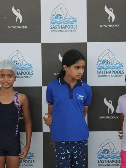 Three young swimmers waiting for their turn on the podium in front of our event backdrop.