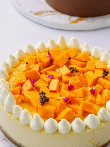 A beautiful mango cheesecake topped with fresh fruit and edible flowers. Our attention to detail in styling elevates the product and makes it look premium.