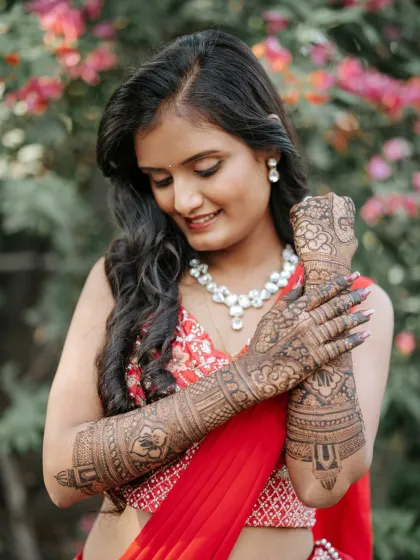 Seeing my brides happy is the best part of my work. Here is a beautiful bride showing off her full-arm traditional mehendi, with the rich henna color complementing her engagement attire perfectly.
