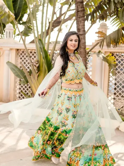A joyful shot of the bride twirling in her beautiful lehenga. Her mehndi is a stunning accessory that adds to the magic of the moment.