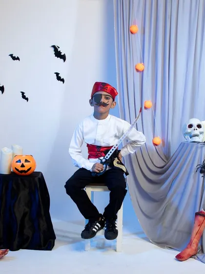 A child dressed as a pirate with an eye patch and sword for Halloween.