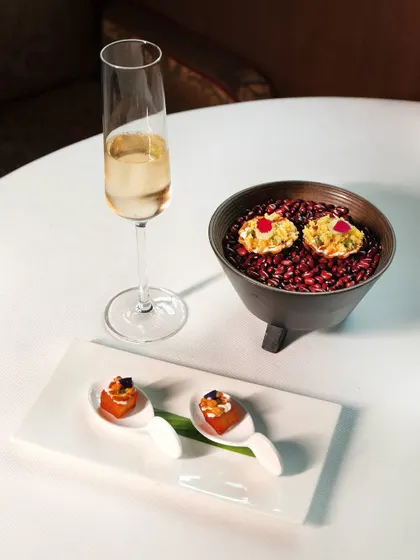 A selection of our street-food inspired snacks, including aloo tikki and kothimbir vadi, paired with a crisp glass of champagne to set the perfect tone for your meal.