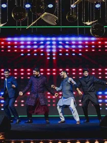 The groom and his friends showing off their coordinated moves during a high-energy sangeet performance.