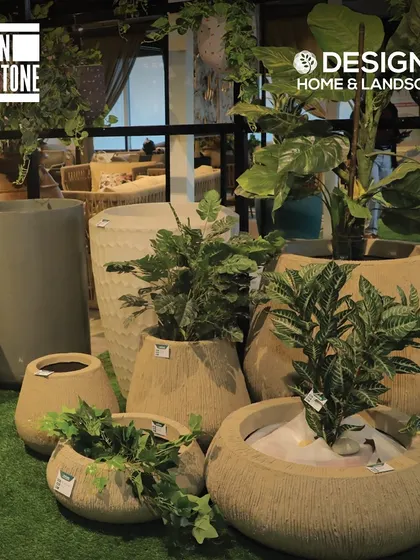 A collection of our stone-finish planters in various shapes and sizes, displayed on artificial grass to give you a feel for how they would look in a garden setting.