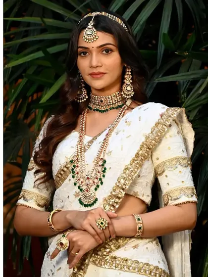 A full portrait showing how the jewellery stands out against the white lehenga, creating a look that is both classic and contemporary.