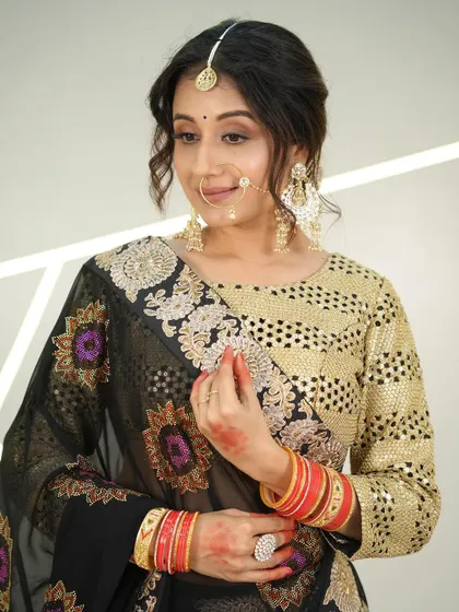 A side profile showing the intricate details of the saree border and the model's henna.