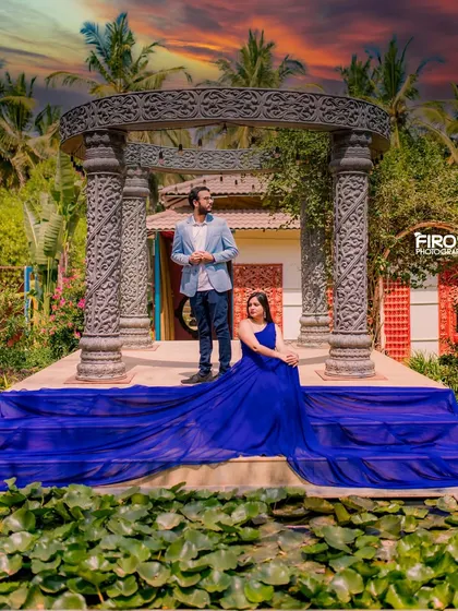 Another beautiful sunset shot at the stone structure. The couple is posed regally, with the blue gown spread across the steps, creating a dramatic and colorful pre-wedding photograph.