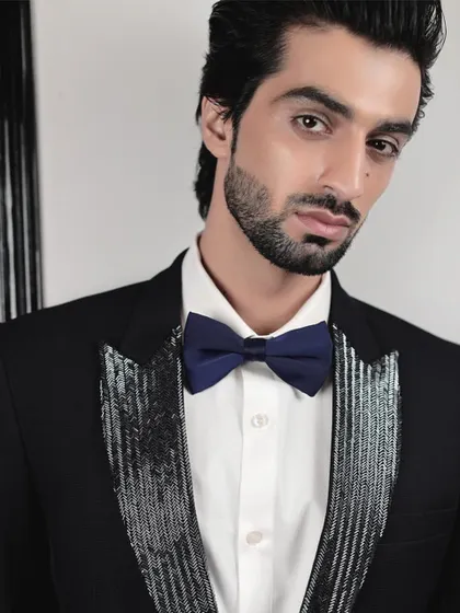A close-up of our tuxedo with silver sequined lapels. The clean lines of the bow tie and crisp white shirt create a perfect frame, highlighting the intricate, handcrafted detail of the jacket.