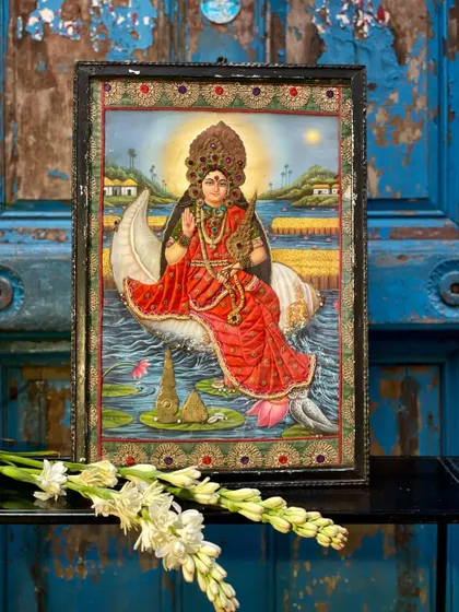 A cloth oleograph of a goddess on a conch shell, set against a rustic blue door. The combination of the vintage print, detailed embroidery, and weathered backdrop creates a truly evocative piece.