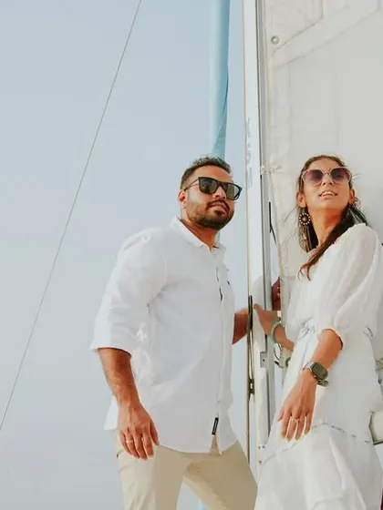 A stylish pre-wedding portrait of a couple posing against the sail of a yacht, looking confident and ready for their future together.