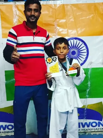 This young champion proudly holds his medal and trophy.