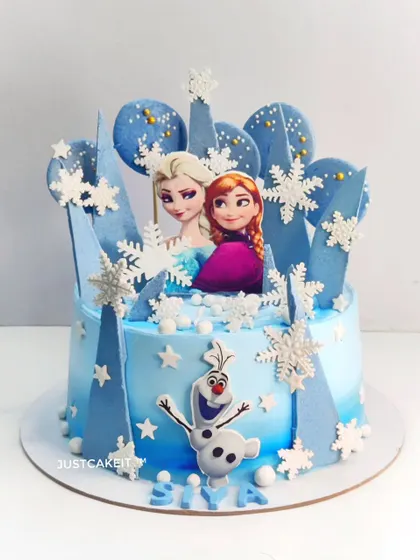 A cool-toned Frozen theme cake with edible snowflakes and chocolate spheres. This design focuses on a blue ombre effect and printed character toppers.