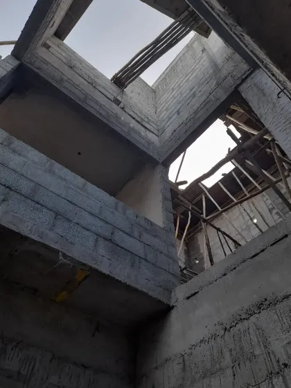 This perspective from inside the construction site shows the complex structural work involved in creating the multi-height volumes. The temporary wooden supports hint at the final form of the ceilings and openings.