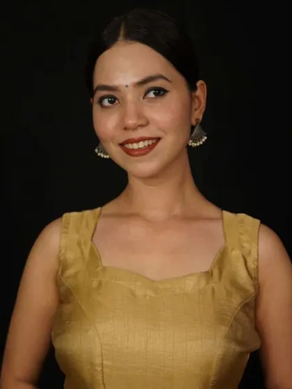 A simple and sweet look, this model wears small silver jhumkas with a plain gold-colored blouse.