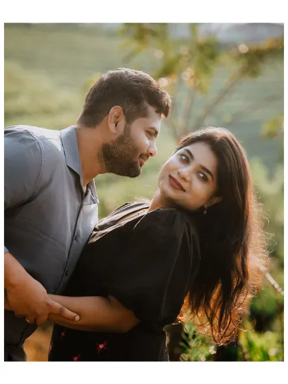A beautiful backlit portrait of a couple in a tea garden, capturing their affection and the golden light.