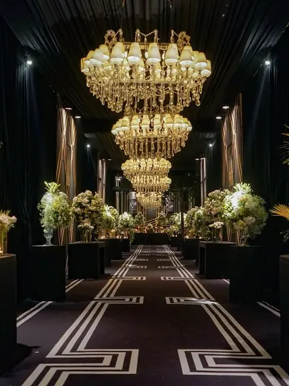 Personal stories are at the heart of my designs. For this anniversary, I created a 'memory lane' entrance, lining the grand, chandelier-lit hall with framed photos that told the couple's 25-year love story, making the celebration deeply personal and touching.