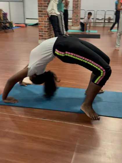 A powerful Urdhva Dhanurasana (Upward Bow Pose) from a young student, showcasing her strength and determination.