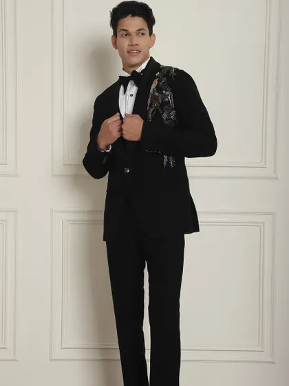 This black tuxedo features beautiful floral embroidery on the lapel, adding a touch of artistry to a classic look.