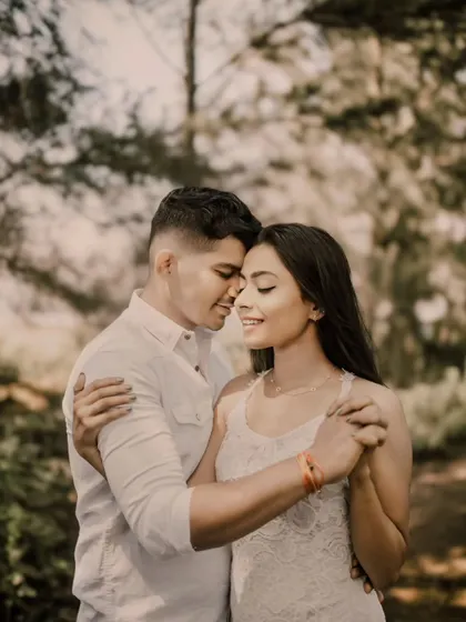 An intimate and tender moment captured in a soft, natural setting. The focus here is entirely on the couple's gentle embrace and peaceful expressions, showcasing the quiet side of their love story.