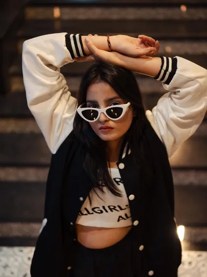 A cool and casual portrait of a model in a varsity jacket. The night setting and her relaxed pose give this a classic, urban feel.