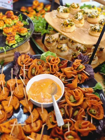 A platter of our unique heart-shaped savory bites and rolled appetizers with a creamy dip. We love to play with shapes and presentation to make our food memorable.