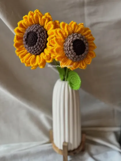 Two crochet sunflowers standing tall in a simple white vase. This minimalist styling shows how just a couple of stems can add a beautiful touch to your decor.