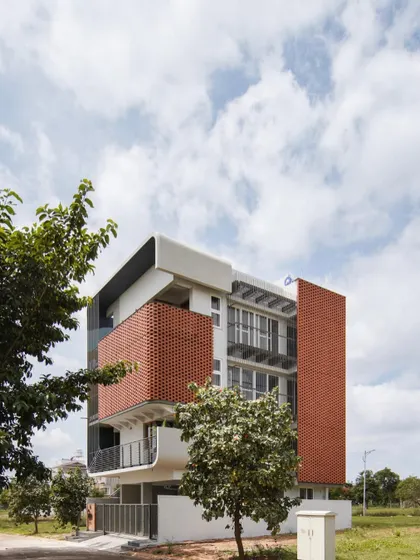 Another view of 'House Belaku', showing the contrast between the solid brick walls and the open balconies.