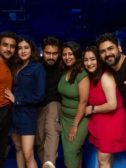 A group of friends enjoying the party atmosphere. The colorful lighting and upbeat music create a fun and festive mood.