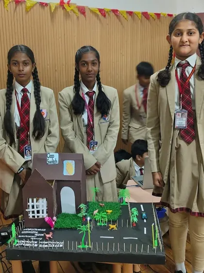 A team of students presents their detailed model project during the robotics competition, showcasing their engineering and design skills.