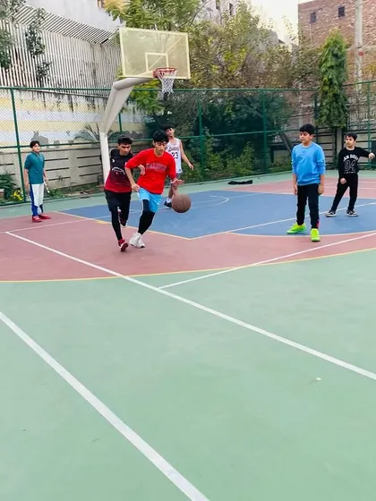 A young player learns to handle the ball against pressure from a defender.