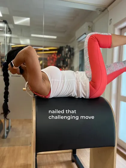 A member nails a challenging core exercise on the Ladder Barrel, celebrating a personal win and showcasing her progress.